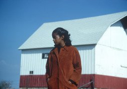 Actress S. Pearl Sharpe (Prissy) in front of a red and white barn.