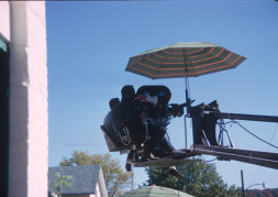 Director Gordon Parks giving direction in megaphone while filming from above.